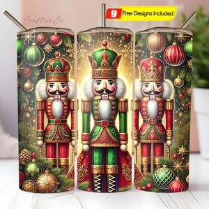 Könnte beinhalten: Drei Edelstahlbecher mit festlichem Weihnachtsdesign. Jeder Becher zeigt eine detaillierte Illustration eines Nussknackersoldaten in Rot, Grün und Gold, umgeben von Ornamenten und Grün. Die Becher enthalten einen Strohhalm.