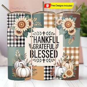 May include: A stainless steel tumbler with a fall theme. The design features sunflowers, pumpkins, and the words "THANKFUL, GRATEFUL, BLESSED" on a patchwork background of black and white plaid, teal, and brown. Includes a straw.