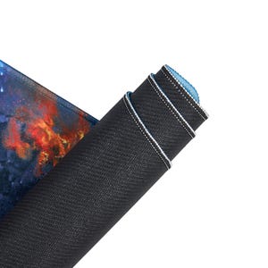 May include: A rolled up gaming mouse pad with a colorful galaxy design on the top and a black rubberized bottom.