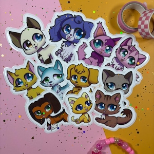 Puede incluir: Una colección de pegatinas de animales de estilo caricatura coloridas con varias razas de perros y gatos. Las pegatinas tienen ojos grandes y expresivos y están en tonos de azul, morado, amarillo, marrón y rosa. Las pegatinas están sobre un fondo rosa y amarillo.