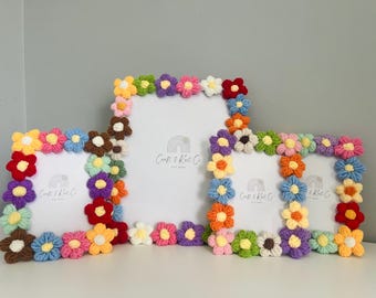 Puede incluir: Tres marcos de fotos rectangulares decorados con flores de ganchillo de colores en tonos rojo, naranja, amarillo, verde, azul, morado y marrón. Cada marco contiene un inserto blanco con un logotipo de arcoíris y el texto Craft & Knit Co.