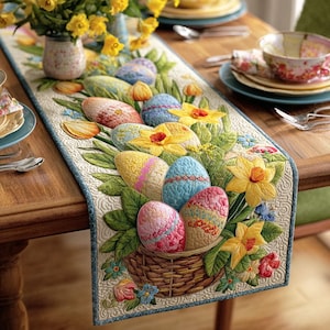 May include: Embroidered Easter table runner featuring a basket of colorful eggs and yellow daffodils. The runner has a light blue border and is placed on a wooden table. The design includes green leaves and other spring flowers.
