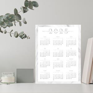 Puede incluir: Un calendario imprimible de 2025 con un fondo de mármol. El calendario es de color gris plateado e incluye los 12 meses del año.