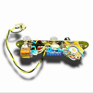 May include: A detailed view of a guitar control plate with various electronic components. The plate features a mix of colors, including yellow, blue, green, and orange wires and components. The design includes knobs, switches, and other hardware.