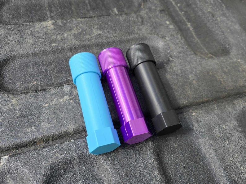 Puede incluir: Tres objetos cil&iacute;ndricos en azul, morado y negro. Cada uno tiene una base hexagonal y una parte superior texturizada. Los objetos azules y morados tienen un acabado brillante, mientras que el negro tiene un acabado mate. Los objetos est&aacute;n dispuestos en diagonal.