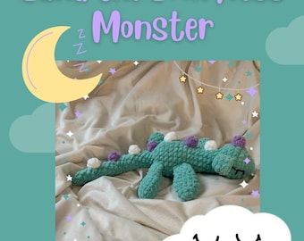 Könnte beinhalten: Ein Häkelmuster für ein grünes und violettes Loch-Ness-Monster namens Luna, mit einem schlafenden Mond und einer Wolke mit einem lächelnden Gesicht. Das Muster ist auf Etsy bei @ashlynn.crochets erhältlich.