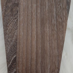 May include: A brown wooden display stand with a scalloped edge and a whitewashed finish. The stand has the word "ILDERKEN" printed on the bottom.