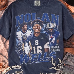 Könnte beinhalten: Ein marineblaues Kurzarm-T-Shirt mit einem Grafikdruck eines Footballspielers namens Nolan Wells. Das Design enthält den Text NOLAN WELLS und JUSTICE FOREVER sowie Bilder des Spielers in Uniform und Blitze.