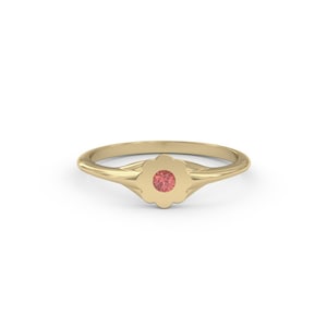 May include: A gold ring with a flower-shaped setting and a small red gemstone in the center.