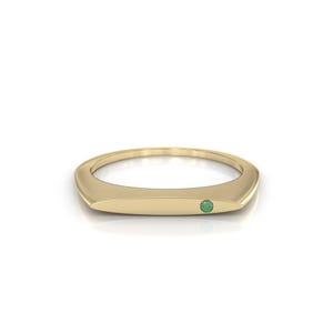 A solid 14K gold signet ring with a minimalist design with an elegant look, accented with an embedded emerald gemstone.