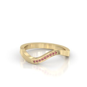 Könnte beinhalten: Ein Goldring mit wellenförmigem Design und einer Reihe von rosafarbenen Edelsteinen.