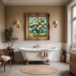 May include: A white clawfoot bathtub with a towel draped over the edge, set in a bathroom with a large framed painting of a flowering tree, a wooden side table with a potted plant, and a wooden vanity with a white sink and drawers.