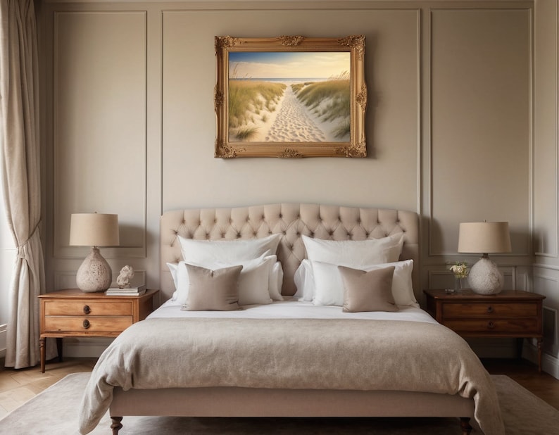 May include: A beige upholstered bed with a tufted headboard and a framed landscape painting above it. Two nightstands with lamps are on either side of the bed.