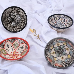 Peut inclure: Quatre bols en céramique avec des motifs géométriques et floraux complexes. Les bols sont de différentes couleurs, notamment le noir, le blanc, le bleu, le rouge, le vert et le jaune.