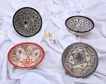 May include: Four ceramic bowls with intricate geometric and floral designs. The bowls are in various colors, including black, white, blue, red, green, and yellow.