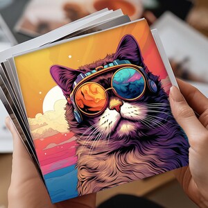 May include: A stack of square art prints featuring a stylized cat wearing sunglasses. The cat has purple and black fur, with orange and blue lenses. The background is a colorful sunset with pink, orange, and yellow hues.