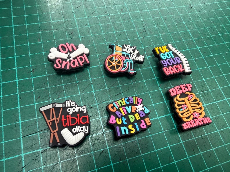 Pu&ograve; includere: Una collezione di ciondoli colorati per scarpe con temi medici e umoristici. I disegni includono frasi come "Oh Snap!", "Let's Roll" e "I've Got Your Back". Altri ciondoli presentano una sedia a rotelle, una gabbia toracica e una gamba rotta.