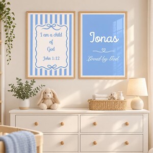 Peut inclure: Deux affiches murales rectangulaires dans des cadres en bois clair. L'affiche de gauche présente des rayures verticales bleues et le texte "I am a child of God John 1:12". Celle de droite est bleu clair avec "Jonas" et "Loved by God".