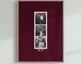 May include: A framed vertical wall art piece featuring a deep burgundy background and a central white photo strip containing three black and white images of people. Below the photo strip, the text NYE 2023 is printed in a simple white font.