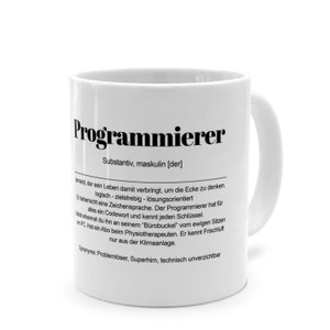 Könnte beinhalten: Weißer Keramikbecher mit dem deutschen Wort "Programmierer" in Schwarz aufgedruckt, zusammen mit einer Definition. Der Becher hat einen gebogenen Henkel und eine glänzende Oberfläche. Der Text ist in einer serifenlosen Schriftart.