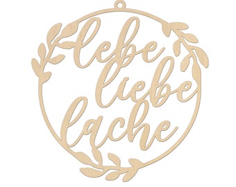 May include: A wooden circle with a leafy wreath design and the text "Lebe liebe lache" in a cursive font.