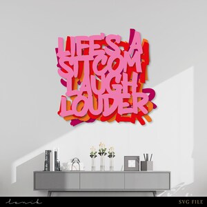 Könnte beinhalten: Rosa und orangefarbene, mehrschichtige Wandkunst mit dem Text "Life's a Sitcom Laugh Louder".