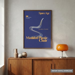 Könnte beinhalten: Gerahmtes Poster mit blauem Hintergrund und den Worten "Space Age" und "Moulded Plastic Chair" in goldfarbenen Buchstaben. Das Poster zeigt ein futuristisches Stuhldesign. Ein Mid-Century-Modern-Schrank und eine orangefarbene Lampe befinden sich im Vordergrund.