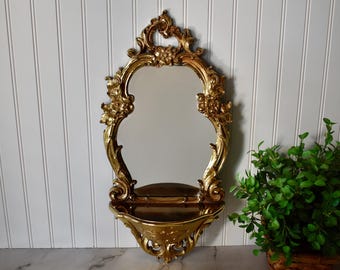 Espejo de pared vintage Syroco con detalles dorados y estante.