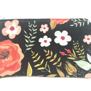 May include: A black zippered pouch with a floral print featuring pink, red, white, and yellow flowers on a black background.