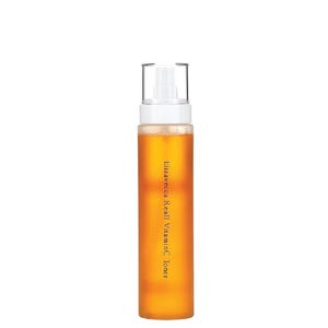 Puede incluir: Una botella transparente de t&oacute;nico Elizavecca Real Vitamin C. La botella contiene un l&iacute;quido de color dorado y tiene un pulverizador blanco. El texto "Elizavecca Real VitaminC Toner" est&aacute; impreso verticalmente en la botella.