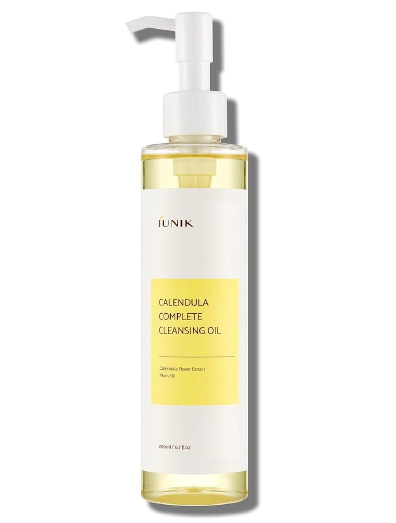 Puede incluir: Una botella transparente de aceite limpiador Calendula Complete con un dispensador de bomba blanco. La botella tiene una etiqueta amarilla con el nombre y los detalles del producto. El l&iacute;quido interior es de color amarillo claro. Contiene 200 ml / 6,7 fl oz.