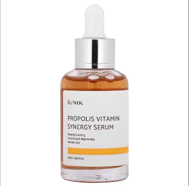 Puede incluir: Botella de vidrio transparente de IUNIK Propolis Vitamin Synergy Serum con cuentagotas blanco y tapa plateada. La etiqueta presenta texto como "Powerful Calming" y "Nourishing & Brightening". La botella contiene 50 ml de s&eacute;rum.
