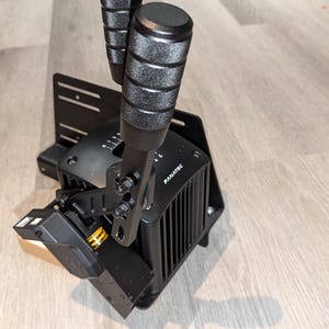 May include: Black shifter with two black handles and a black base with the word "Fanatec" printed on it.