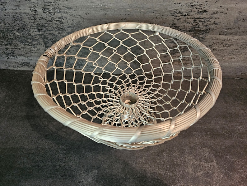May include: A silver wire mesh basket with a circular base and a woven rim. The basket is made of a fine wire mesh and has a delicate, airy appearance.