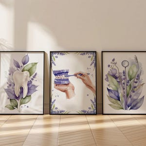 May include: Three framed dental art prints. The prints feature watercolour illustrations of a tooth, a model of teeth being brushed, and dental tools. The colour palette includes shades of purple, green, and white, with floral accents.