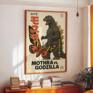 Op de afbeelding: Een ingelijste vintage poster met Godzilla en Mothra. De poster heeft Japanse tekst en de Engelse titel "Mothra vs. Godzilla". De afbeelding toont een grote vlinder en een dreigende Godzilla-figuur, tegen een crèmekleurige achtergrond.