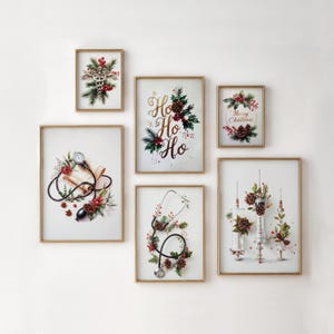 Puede incluir: Una colección de seis impresiones artísticas enmarcadas con marcos dorados. Las impresiones presentan decoraciones navideñas de temática médica, incluyendo un caduceo, estetoscopio, jeringas y las palabras "Ho Ho Ho" y "Merry Christmas". La obra de arte incorpora piñas y bayas rojas.
