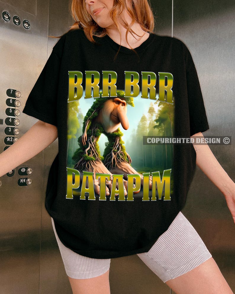 May include: Black t-shirt featuring a green, yellow and brown graphic of a creature with a long nose and the text "BRR BRR PATAPIM".