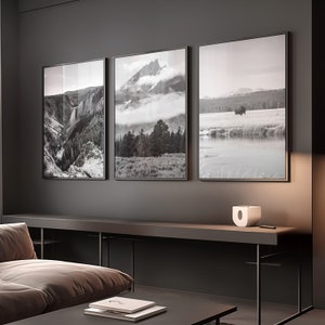 May include: Three black framed landscape photographs of nature scenes. The left photo shows a waterfall in a canyon. The middle photo shows a mountain range with clouds and trees. The right photo shows a lake with a bison in the distance.