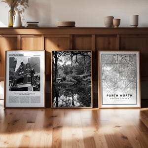 Op de afbeelding: Drie zwart-wit ingelijste prints op een houten plank. De prints zijn van een stadsbeeld, een bos scène en een kaart van Fort Worth, Texas. De tekst op de kaart luidt "Fort Worth, Verenigde Staten".