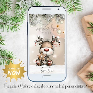 Könnte beinhalten: Ein Smartphone zeigt eine digitale Weihnachtskarte mit einem Cartoon-Rentier, das einen sternförmigen Keks hält. Die Karte trägt den Text "Frohe Weihnachten Wunsch" und den Namen "Emilia". Eine goldene Grafik "Download Now" ist sichtbar.