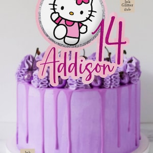 May include: A purple cake with a Hello Kitty cake topper, the number 14, and the name "Addison" in pink. The cake has purple frosting with dripping icing and is decorated with purple frosting and cherries.