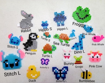 Puede incluir: Una colección de diseños coloridos y pixelados de animales y personajes, incluyendo un conejo, un pingüino, una rana, un hipopótamo, una tortuga, un dinosaurio, una ballena, un conejo, Grogu, una vaca, un pato, una mariposa, una abeja y Stitch.