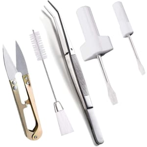 May include: A set of five tools for cleaning and maintaining sewing machines. The set includes a pair of small gold scissors, a white brush with a long chain, a pair of silver tweezers, a white cotton swab on a stick, and a white cotton swab on a stick with a white plastic base.