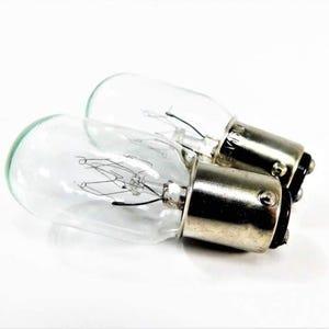 May include: Two clear glass light bulbs with metal bases. The bulbs are small and have a standard screw-in base.