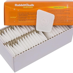 May include: A box of 50 white tailor's chalk pencils in a triangular shape. The box is orange and white and has the text "RabbitChalk Tailor's Chalk" on the front. The box also has a list of instructions and characteristics for using the chalk.