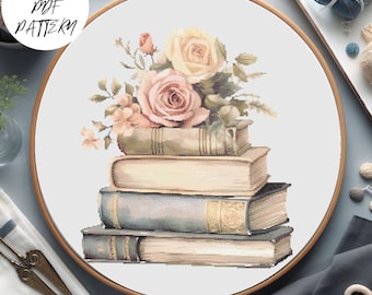 Puede incluir: Una pila de cuatro libros antiguos con un ramo de rosas rosas y crema en la parte superior. Los libros están dispuestos en tamaño decreciente, con el libro más grande en la parte inferior y el más pequeño en la parte superior. Las rosas están dispuestas en un estilo suelto y natural.