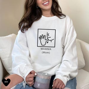 May include: White sweatshirt with a black graphic of a hand signing "mamma" with the text "Mamma (Mom)" underneath.