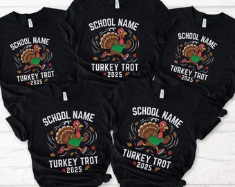 May include: Black t-shirts with a cartoon turkey graphic. The turkey is running and wearing a green shirt. The text on the shirts reads "SCHOOL NAME" above the turkey and "TURKEY TROT 2025" below the turkey. Autumn leaves surround the turkey.