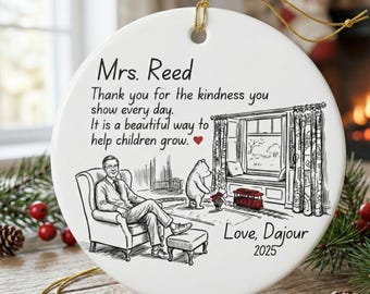 Puede incluir: Adorno navideño de cerámica blanca con una cuerda dorada para colgar. El adorno presenta una ilustración en blanco y negro de un hombre, un oso y un tren. El texto incluye "Mrs. Reed" y un mensaje de agradecimiento, con "Love, Dajour 2025".